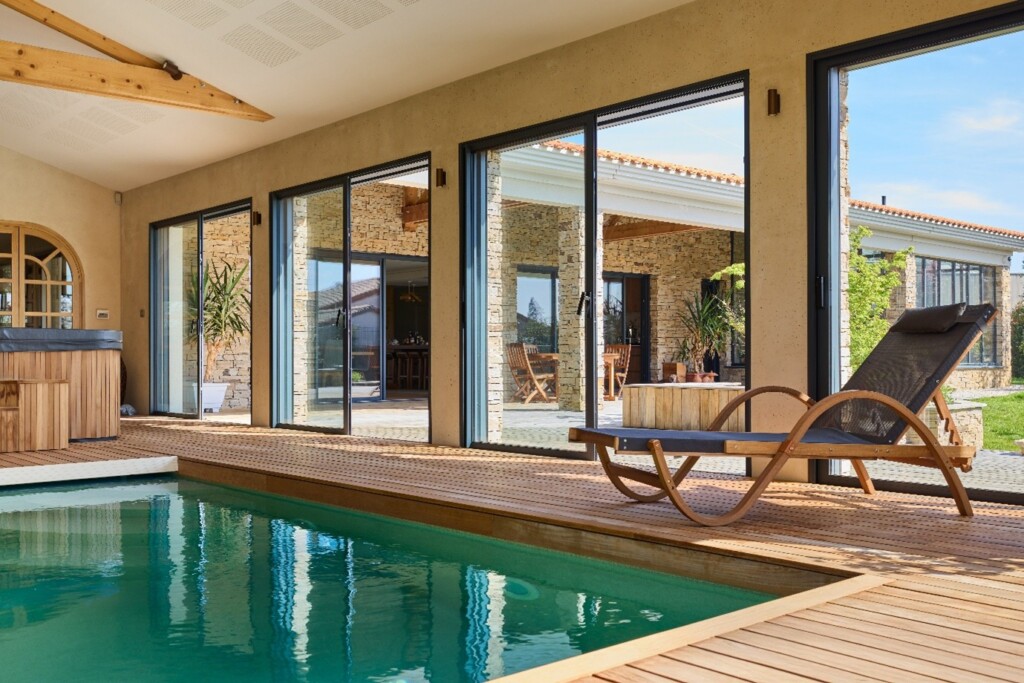intérieur de maison avec piscine et des fenêtres coulissantes en aluminium