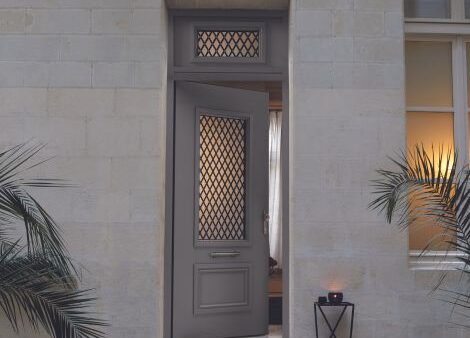 porte d'entrée maison ancienne avec une grille traditionnelle et une imposte coordonnée