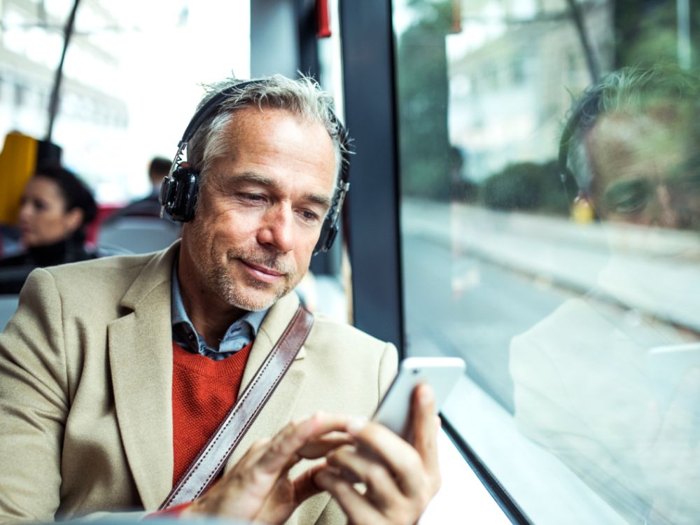 homme dans un bus tenant un téléphone dans sa main
