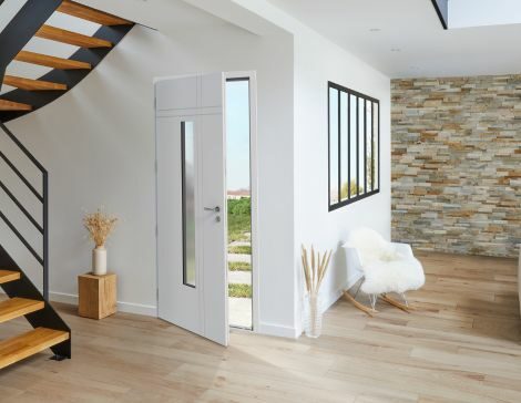 porte d'entrée aluminium blanche vitrée dans un intérieur de maison moderne