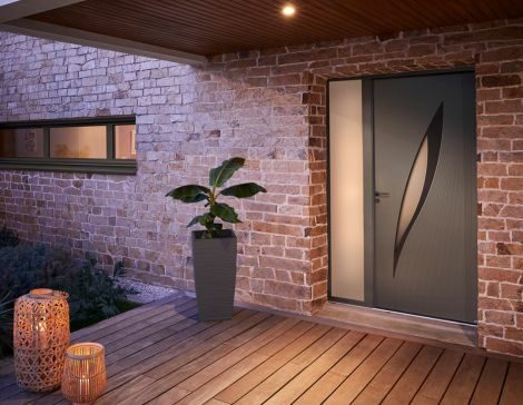 porte d'entrée avec tierce en aluminium sur une façade de maison en brique